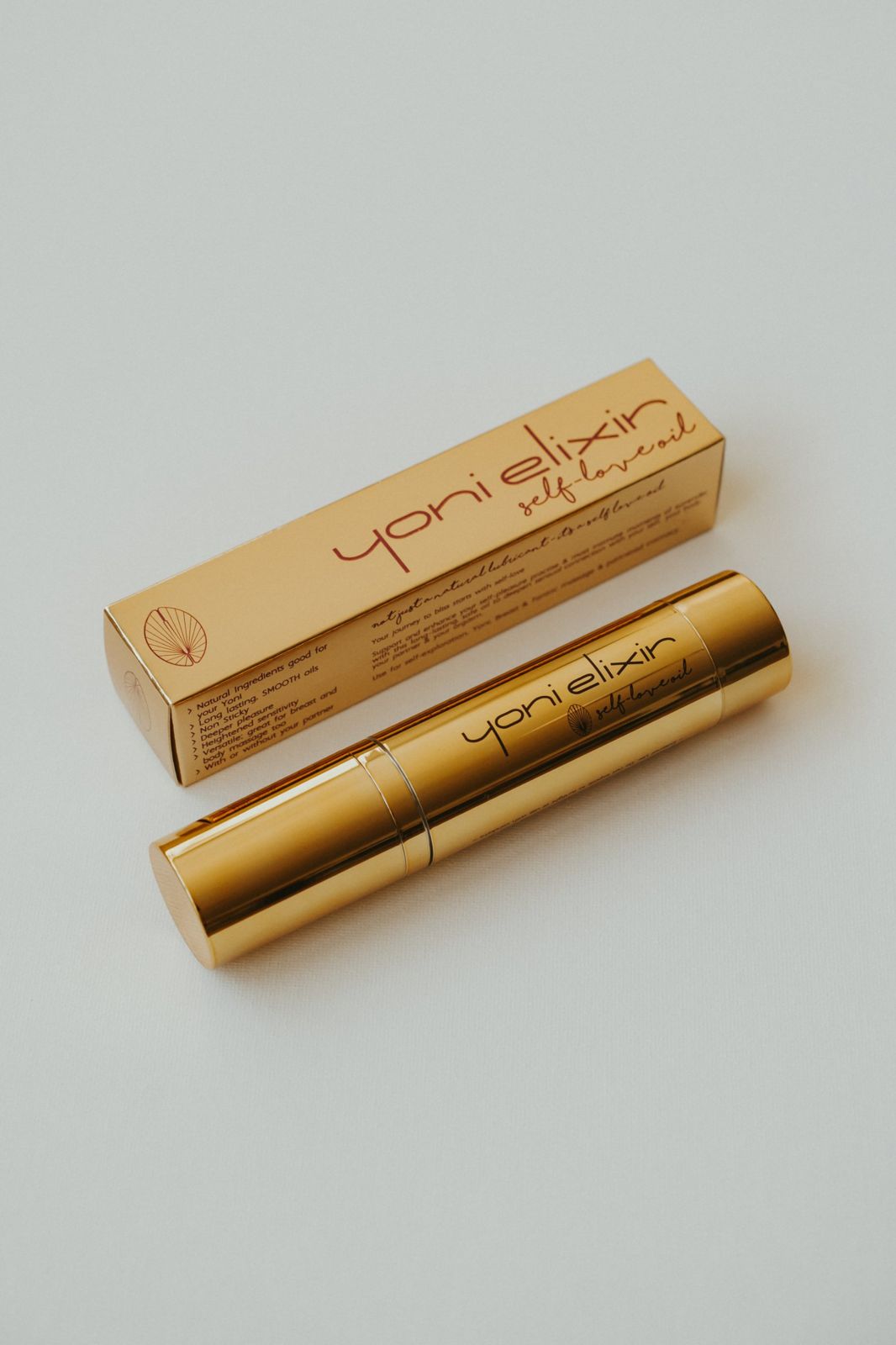 Yoni Elixir gold bottle beside its box